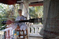 Phuoc Thanh buddhist pagoda. Buddhist worshipper rings bell. Cai be. Vietnam.