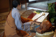 Chua Tu An Buddhist temple. Monk at buddhist ceremony. Monk playing on a wooden fish (percussion instrument).