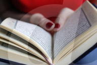 Woman reading the Quran. Close-up.