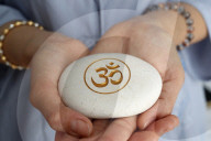 The Om or Aum symbol of Hinduism and Buddhism on a white stone.