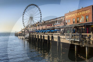 Seattle Great Wheel on Pier 57 in the foreground in late afternoon sunshine. Seattle, Washington State, USA, North America