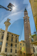 Sun peaking from street lamp and clocktower of Palladian Basilica in Piazza Signori, Vicenza, Veneto, Italy, Europe