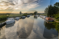Boats and cottage near Horsey Mill at sunset, Norfolk Broads, Norfolk, England, United Kingdom, Europe