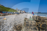 View of fishing baskets on the beach and Parish Church overlooking pier on a summer day, Cromer, Norfolk, England, United Kingdom, Europe