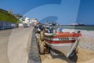 View of Cromer Pier and boats on shingle beach on a summer day, Cromer, Norfolk, England, United Kingdom, Europe
