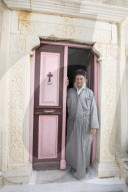 Greek Orthodox priest standing in doorway of Moni Taxiarchon Monastery, Serifos, Cyclades, Aegean Sea, Greek Islands, Greece