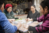 Women playing traditional Chinese game of Mahjong on street, Dali, Yunnan Province, China