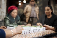 Women playing traditional Chinese game of Mahjong on street, Dali, Yunnan Province, China