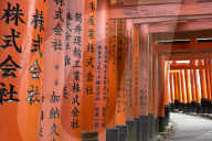 Prayers written in Japanese on the red wooden Torii Gates at Fushimi Inari Shrine in Kyoto.