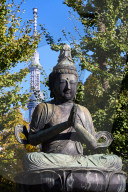 Kannon Bosatsu Buddha sculpture at the Sensoji Temple with the Sky Tree Tower in the background, Asakusa, Tokyo.