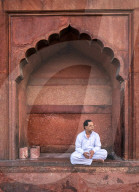 Portrait Muslim man in arch, Jama Masjid, one of the largest mosques in India.