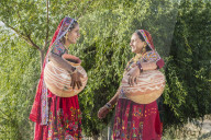 Two Ahir Women in traditional colorful cloth carrying water in a clay jug, Great Rann of Kutch Desert, Gujarat, India