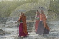 Fakirani women in traditional cloth walking in the desert with a basin on their head, Great Rann of Kutch Desert, Gujarat, India