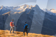 Hikers admiring the mountains in Autumn Season in Stelvio National park in Brescia province, Lombardy district, Italy, Europe.
