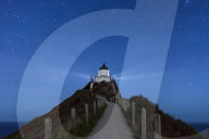 8206 Nugget Point lighthouse under star filled sky, Kaka Point, New Zealand