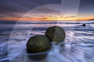 The Moeraki Boulders with dramatic sunrise at Moeraki Beach, Otago, New Zealand