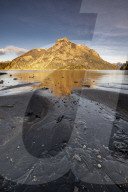 Black lava beach with reflected mountain, Barilochie, Patagonia, Argentina.