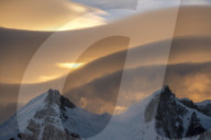 Lenticular clouds above snow covered mountain range, El Chalten