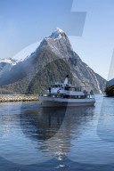 Milford Adventurer Cruise ship at Milford Sound with snow capped Mitre Peak, Fiordland National Park, New Zealand