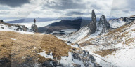 Hiker admiring view towards the Old Man of Storr, near Portree, Isle of Skye, Inner Hebrides, Highland, Scotland.
