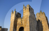 The medieval barbican and gatehouse of Alnwick Castle, sunset, Alnwick, Northumberland, England, UK