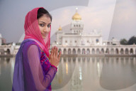 A young woman worshipping at a Sikh temple in Delhi, India.