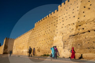 Women in traditional dress walking alongside the walls of the Kasbah Cherada in Fez Medina, UNESCO World Heritage Site, Morocco