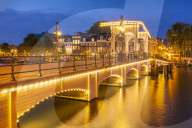 Illuminated Magere brug or Skinny bridge at night spanning the river Amstel , Amsterdam, Netherlands, Holland, EU, Europe