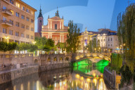 The pink Franciscan Church of the Annunciation Ljubljanica river and the triple bridge at night Ljubljana Slovenia EU Europe