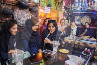 Iran, Isfahan, Azadegan teahouse, young women smoking a water pipe