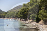 People relaxing in the calm waters of the beautiful bay of Playa (Platja) de Formentor on the northern coast of Mallorca