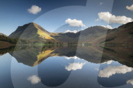 Perfect reflections on a tranquil Lake Buttermere in the Lake District, Cumbria, England. Autumn (October) 2018.