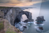 Colourful dawn sky above the Green Bridge of Wales natural arch in Pembrokeshire, Wales, UK. Spring (March) 2019.