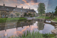 Colourful sunrise above the pretty village of Lower Slaughter in the Cotswolds, Gloucestershire, England. Spring (May) 2019.