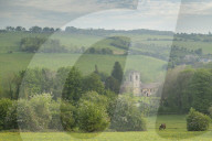Rural church in beautiful Cotswolds countryside on a hazy spring morning, Naunton, Gloucestershire, England. Spring (May) 2019.
