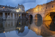 Evening lights illuminating Pulteney Bridge in Bath, Somerset, England. Summer (June) 2019.