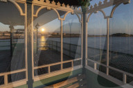 Sunset reflected in the glass shelters on Clevedon Pier, Cleveon, Somerset, England. Summer (July) 2019.