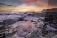 Colourful Cornish sunset above rocky ledges near Polzeath, Cornwall, England. Spring (April) 2018.