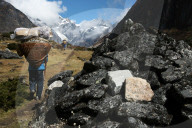 Porters pass a mani-wall, high Khumbu, Nepal