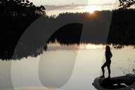Woman looking out across a lake in rural Finland