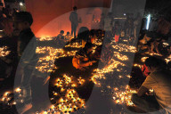 Hindu devotees placing lit puja lamps in temple courtyard to celebrate annual festival of Shivraatri, Koraput district, Odisha