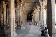People resting in the stone pillared corridor inside the 11th century Brihadisvara Cholan temple, Thanjavur, Tamil Nadu