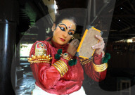 Performer carefully applying make-up with bamboo stick for a Kathakali dance performance of folk mythologies, Nilambur, Kerala