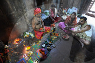Priest performing puja ceremony with couple inside 10th century Mukteswar temple, Bhubaneswar, Odisha