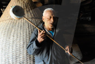 Naga elder playing domestic stringed gourd and bamboo instrument and singing, Phek, Nagaland