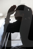 Silhouette of woman praying in a church.