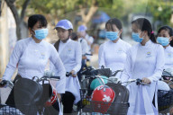 Students dressed in Ao Dai on the way to school. Cai Be. Vietnam.