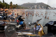 Sunday at the beach. Vietnamese families swiming in the south China Sea. Hang Dua Bay. Vung Tau. Vietnam.
