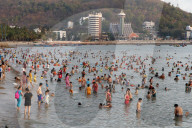 Sunday at the beach. Vietnamese families swiming in the south China Sea. Hang Dua Bay. Vung Tau. Vietnam.
