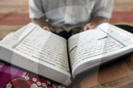 Old man reading quran sitting on carpet In mosque. Phnom Penh. Cambodia.